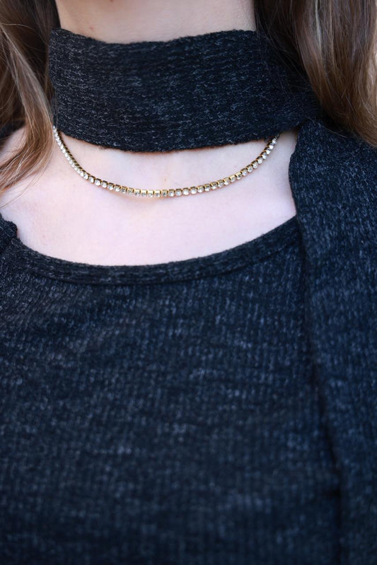 طقم ملابس ناعمة من الصوف المحبوك بتفاصيل دقيقة، يتضمن شالاً أسود.