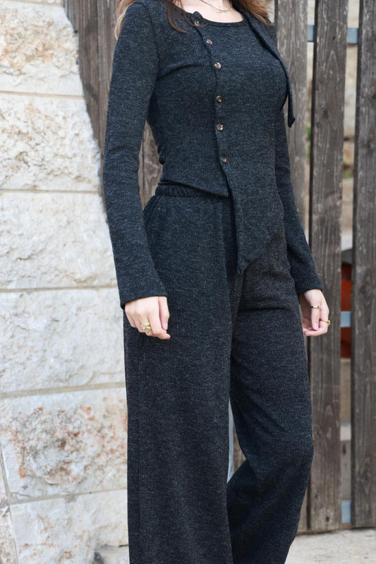 طقم ملابس ناعمة من الصوف المحبوك بتفاصيل دقيقة، يتضمن شالاً أسود.