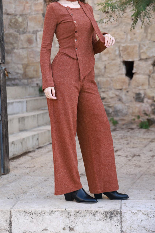 طقم ملابس ناعمة من الصوف المحبوك بتفاصيل دقيقة، يتضمن شالاً بنياً.