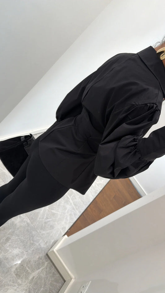 قميص أسود بأكمام مطوية مزينة بتفاصيل مطوية