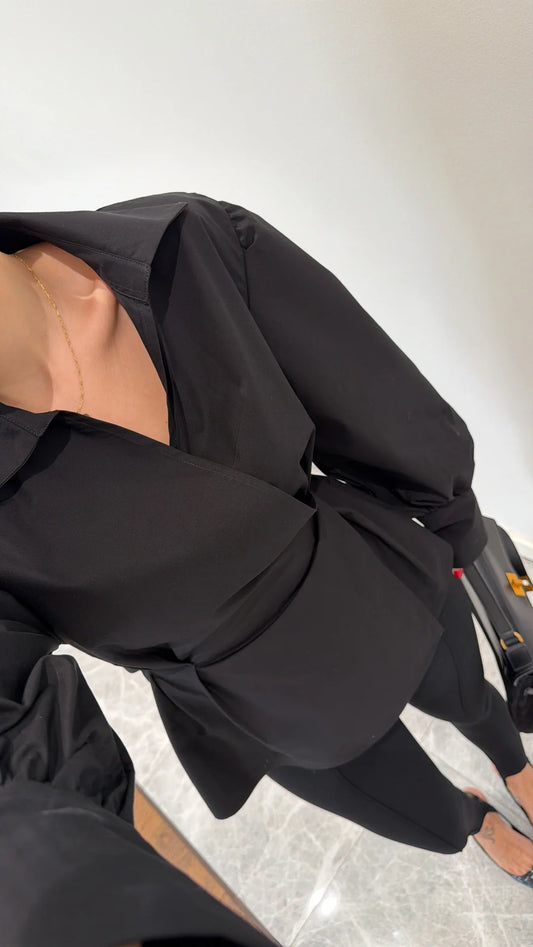 قميص أسود بأكمام مطوية مزينة بتفاصيل مطوية