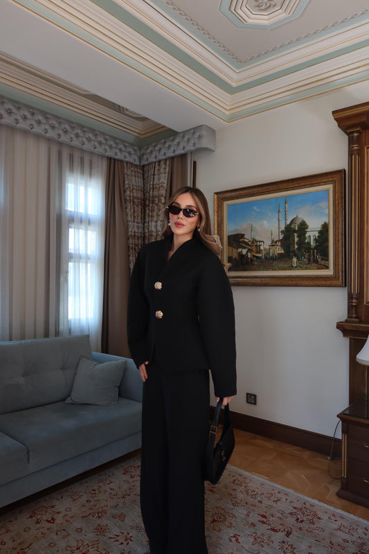 بدلة سوداء بأكمام بالون وأزرار ذهبية