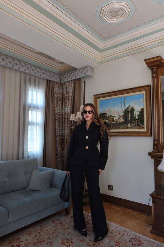 بدلة سوداء بأكمام بالون وأزرار ذهبية