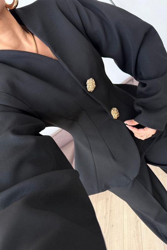 بدلة سوداء بأكمام بالون وأزرار ذهبية
